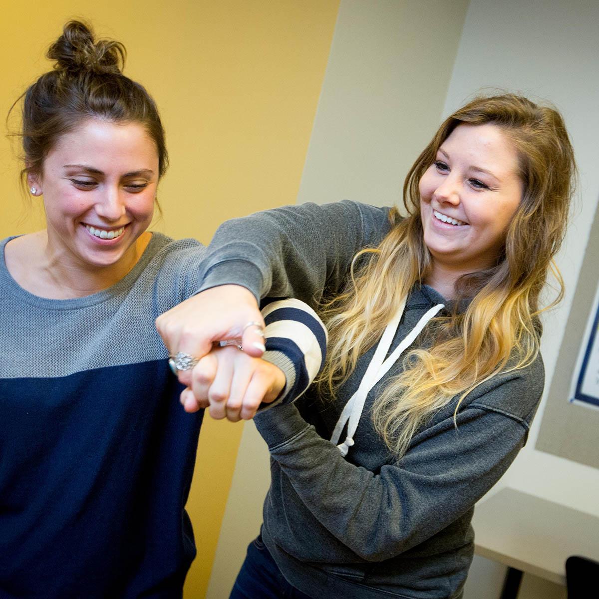 两个职业治疗专业的学生微笑着一起工作的照片