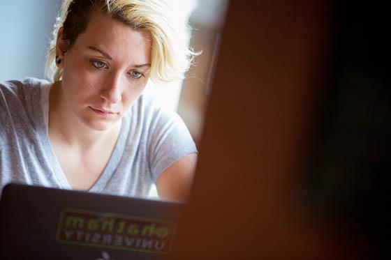 图为一位波胆网站的学生在咖啡厅里看着她的笔记本电脑.