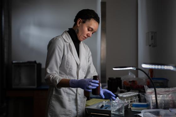 一个穿着白色实验室大褂的女人在实验室工作的照片