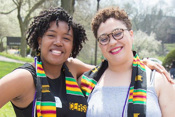 两名黑人妇女的照片, 波胆网站的毕业生, 穿着多元文化的毕业礼服，对着镜头微笑