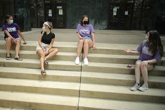 四名波胆网站女学生的照片, 戴着面具，穿着查塔姆的t恤, 所有人都坐在图书馆的台阶上