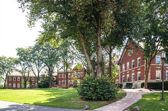 Photo of redbrick academic buildings framing a green quad on Chatham University's Shadyside campus. 