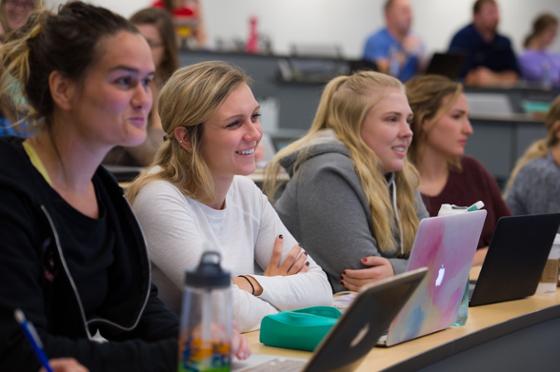 Photo of smiling Chatham University students paying attention to a lecture