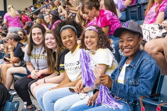 Photo of Chatham University students at a Pittsburgh Pirates baseball game, posing for the camera while seated