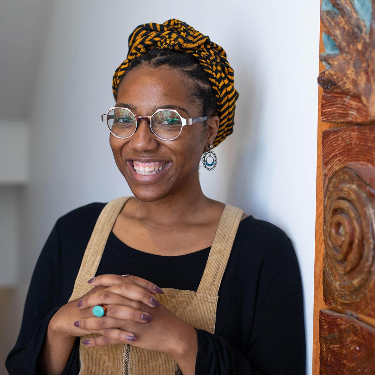 Ciera Marie Young摄, 戴六角形眼镜的黑人妇女, 在一幅彩色的画前微笑