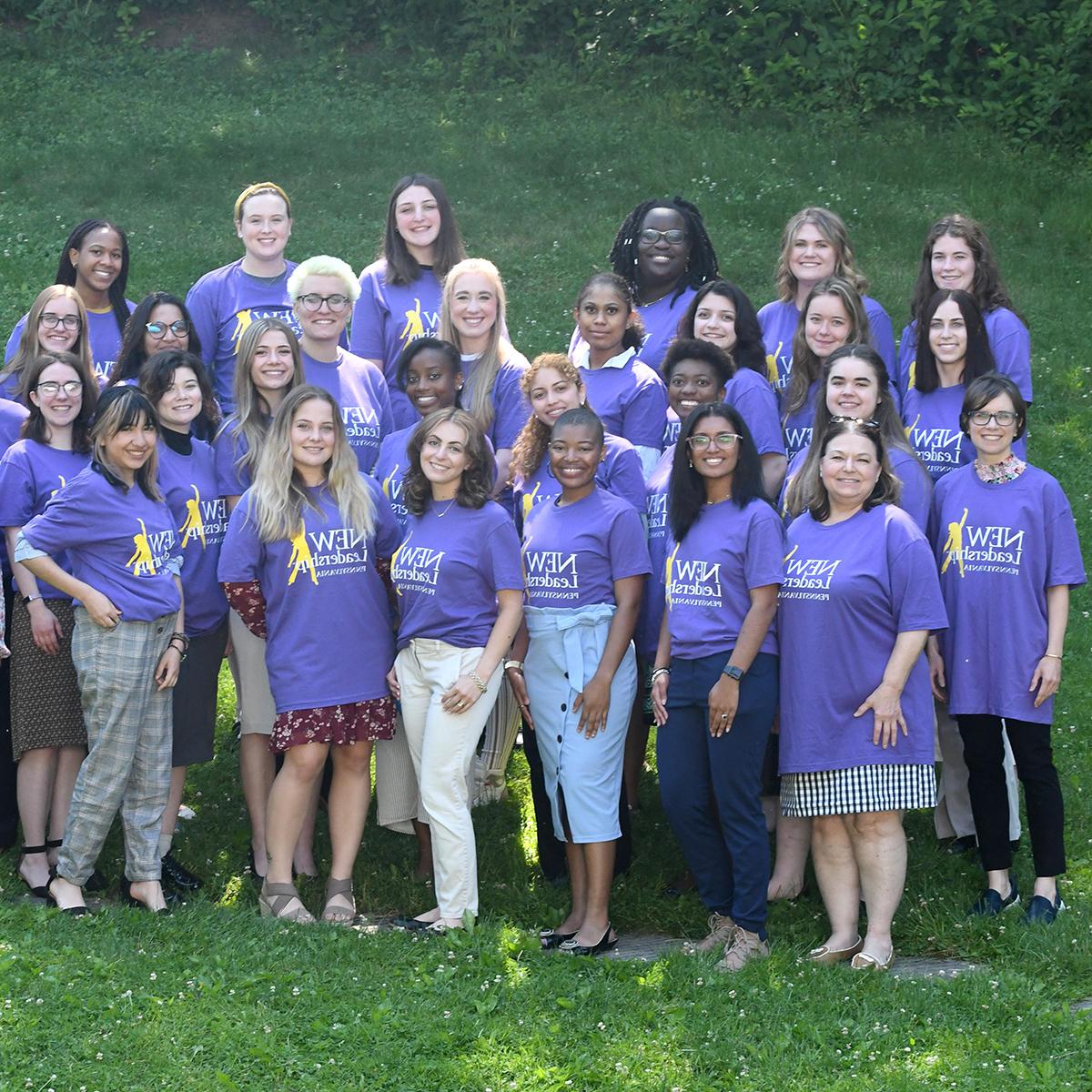 图为一群穿着紫色新领导t恤的女性在外面摆姿势拍照